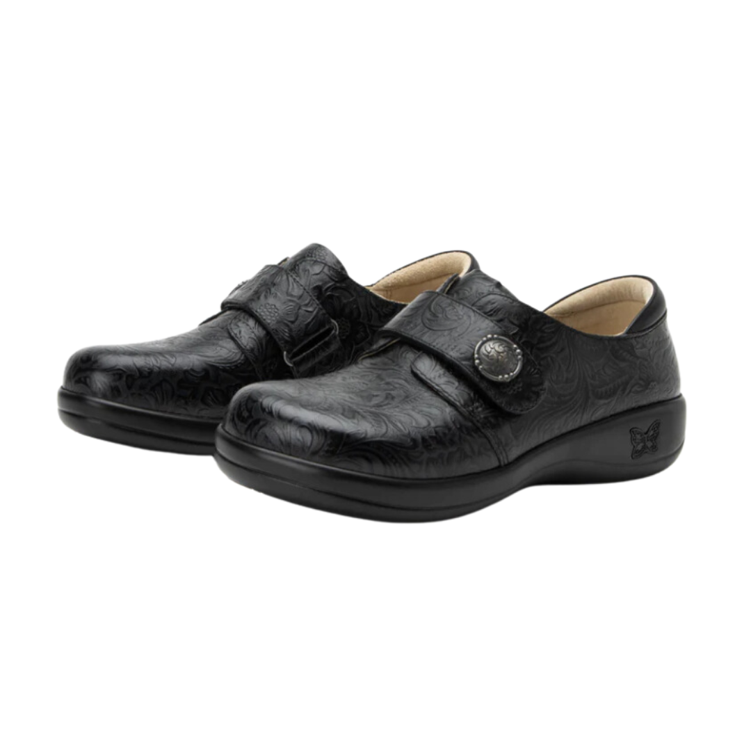 Angled view of Women’s Alegria Joleen casual slip-on in all black – featuring smooth leather upper, cushioned insole, elastic gore panels, and flexible outsole.