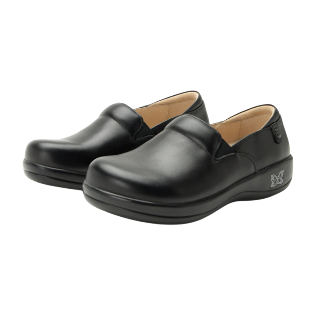Angled view of Women’s Alegria Keli casual slip-on in all black – featuring matte finish leather, cushioned footbed, elastic panels for a snug fit, and durable outsole.