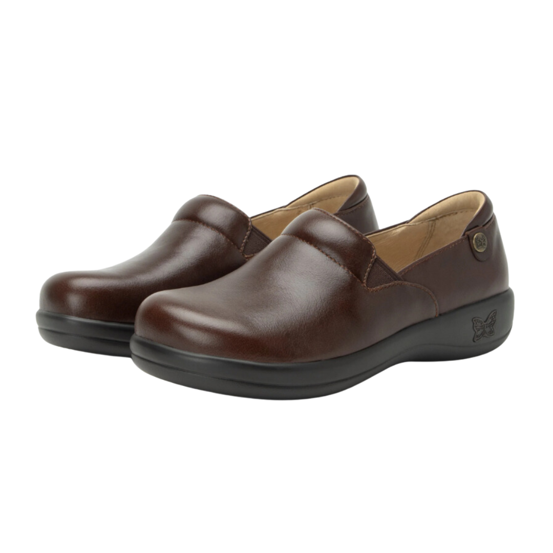 Angled view of Women’s Alegria Keli casual slip-on in brown and black – featuring durable leather with embossed details, supportive cushioned insole, and flexible outsole for natural movement.