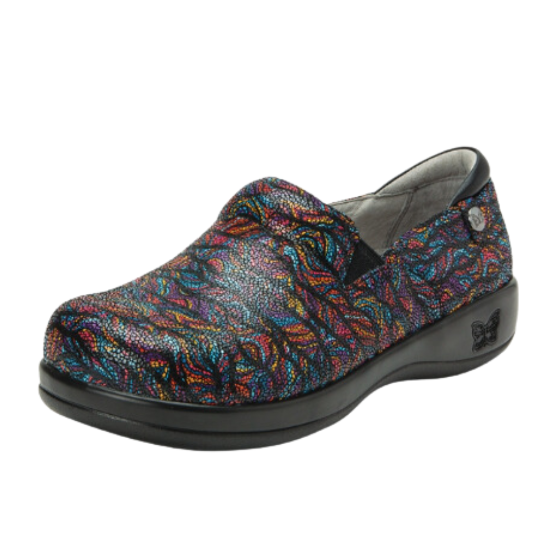 Angled view of Women’s Alegria Keli casual slip-on in black with multi-colors – featuring artistic printed upper, supportive footbed, breathable materials, and durable outsole.