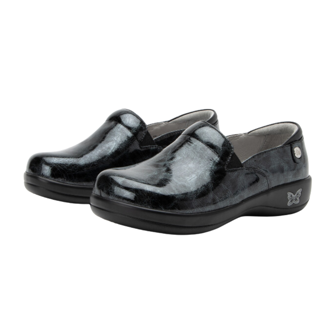 Angled view of Women’s Alegria Keli casual slip-on in black – featuring woven fabric upper, cushioned insole, slip-on convenience, and flexible outsole.
