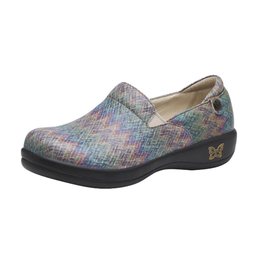 Angled view of Women’s Alegria Keli Woven Wonder casual slip-on in black with multi-colors – featuring a handwoven textile upper, cushioned memory foam footbed, elastic gore panels for easy wear, and a flexible, durable rubber outsole.