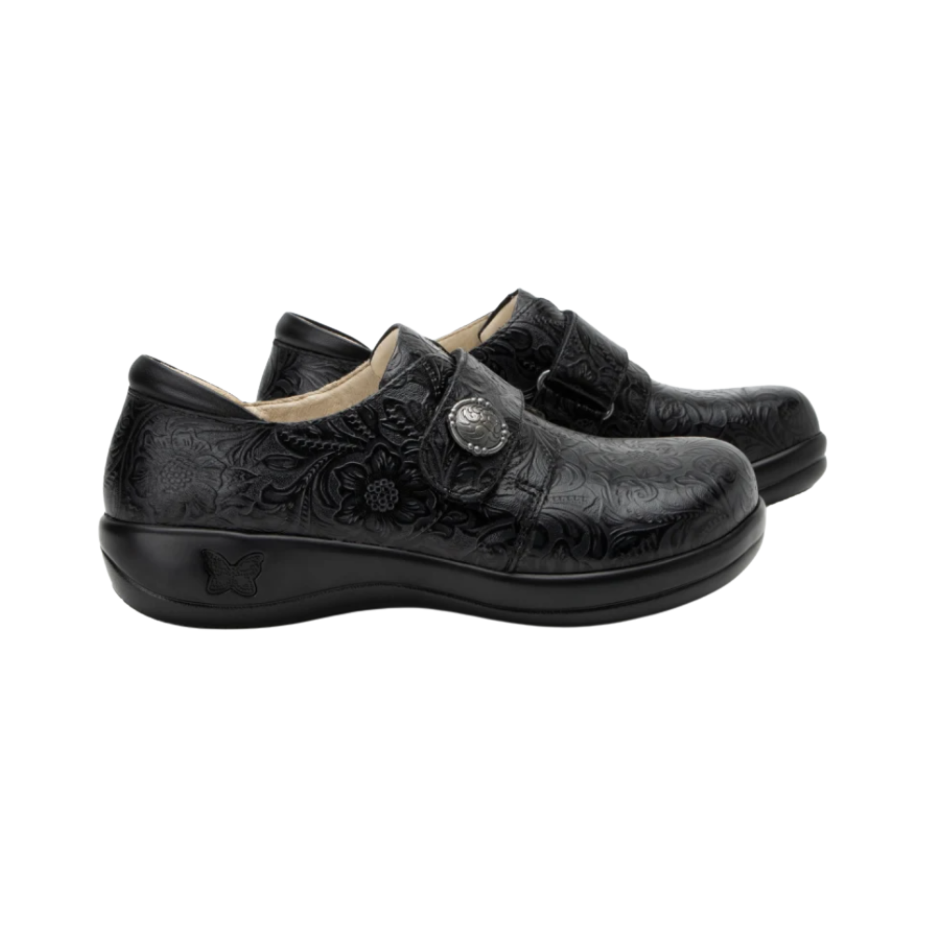 Side View of Women’s Alegria Joleen Work shoe in Tar Tooled – featuring a mild rocker outsole that supports smoother strides and reduces joint strain, a hook-and-loop strap with decorative hardware for adjustable fit, and premium tooled leather for a refined professional appearance.