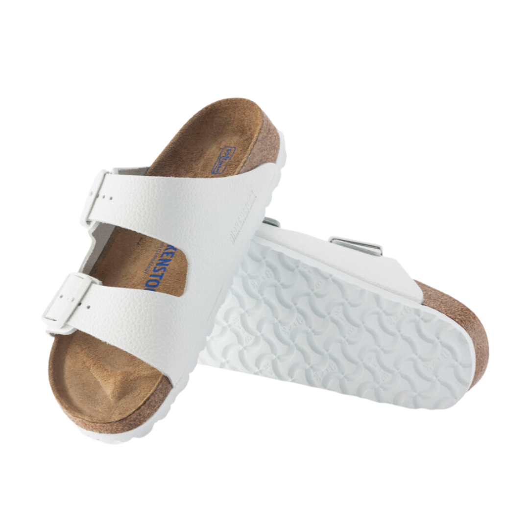 Angled view of Women’s Birkenstock Arizona Soft Footbed leather sandal in white - crafted with smooth leather straps for a classic look, a soft footbed that cushions and supports the foot, and a cork sole engineered for long-lasting durability and natural foot movement.