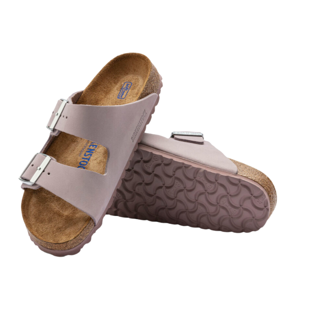 Angled view of Women’s Birkenstock Arizona Soft Footbed nubuck leather sandal in light purple - featuring soft nubuck leather straps with buckle closures, a plush soft footbed that molds to your foot for personalized comfort, and a cork sole that absorbs shock and supports the foot’s natural shape.