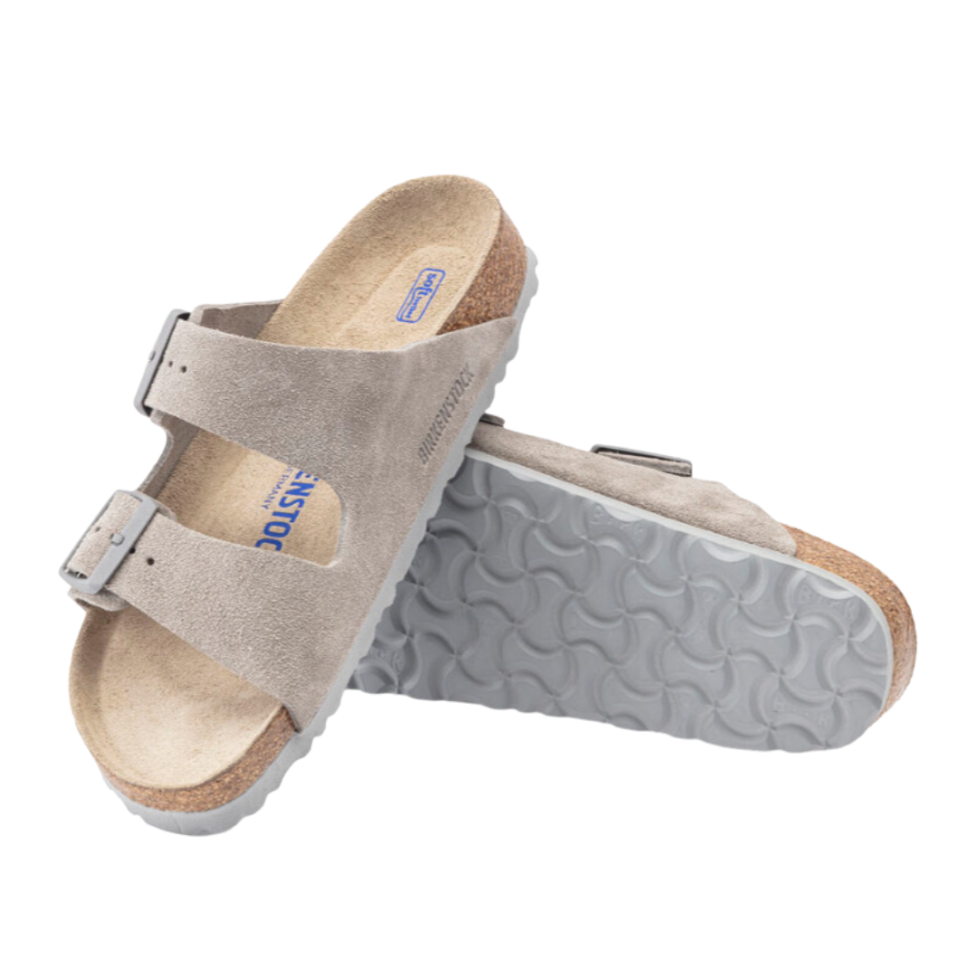 Angled view of Unisex Birkenstock Arizona Soft Footbed suede leather sandal in tan - featuring soft suede leather straps that offer a comfortable, breathable fit, a soft footbed for enhanced cushioning, and a cork outsole designed to adapt to your foot’s natural contours.
