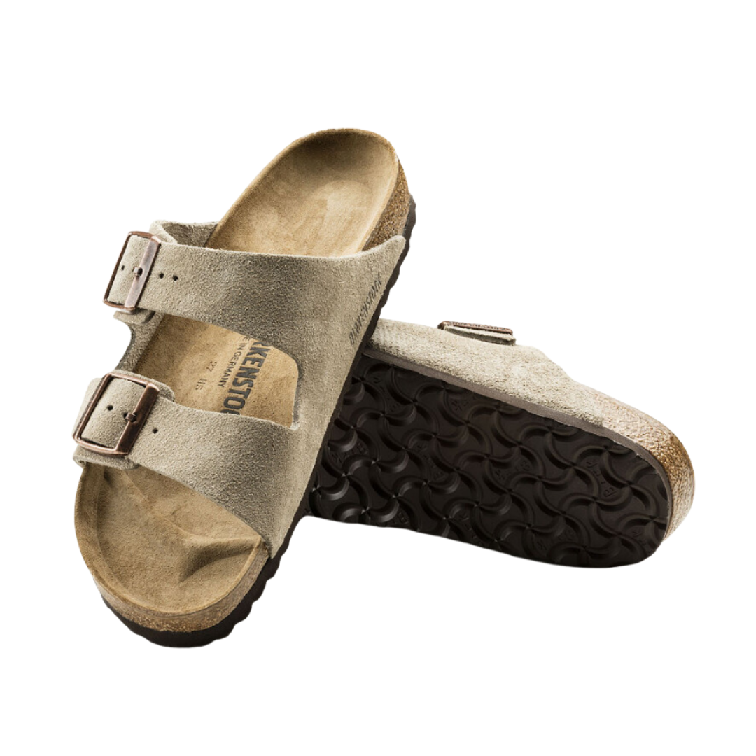 Angled view of Women’s Birkenstock Arizona Suede Leather sandal in taupe - crafted with soft suede leather straps that provide a luxurious feel, adjustable buckle closures for secure fit, and a cork footbed lined with suede to keep feet comfortable and dry while offering excellent arch support.