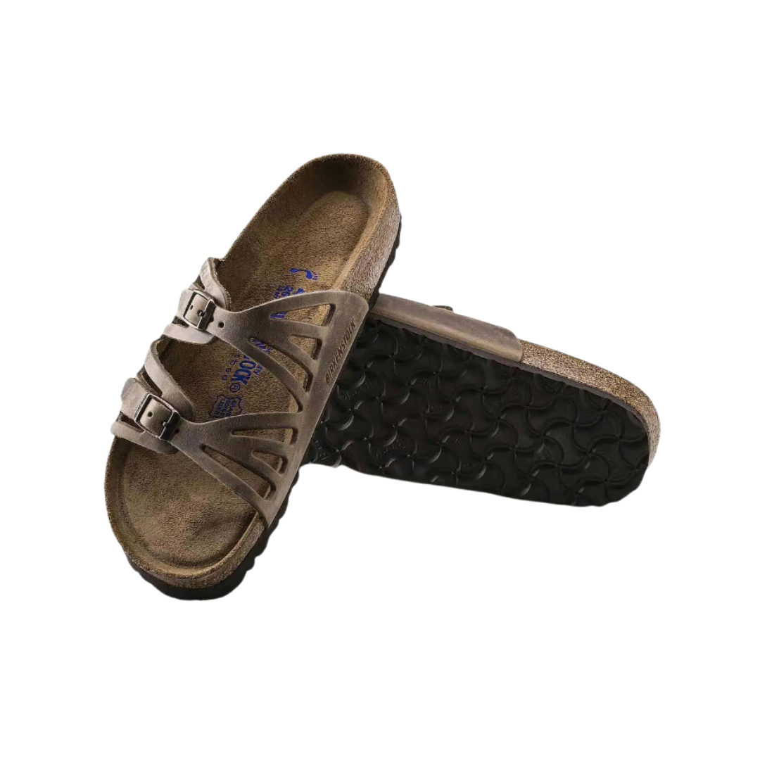 Angled view of Women’s Birkenstock Granada Soft Footbed sandal in dark brown - highlighting a soft footbed that provides extra padding underfoot, adjustable two-strap design for versatile fit adjustments, and a durable cork sole that delivers excellent shock absorption and breathability.