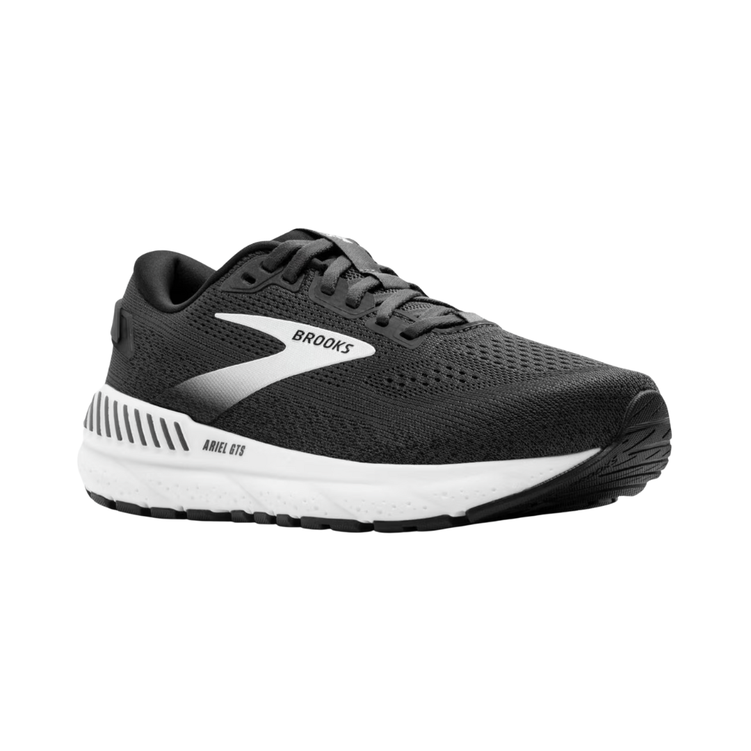 Side view of Women’s Brooks Ariel GTS 24 running shoe in ebony, black, and white – featuring engineered mesh upper for breathability, GuideRails support system to stabilize the foot and reduce excess movement, and BioMoGo DNA midsole for adaptive cushioning and shock absorption.