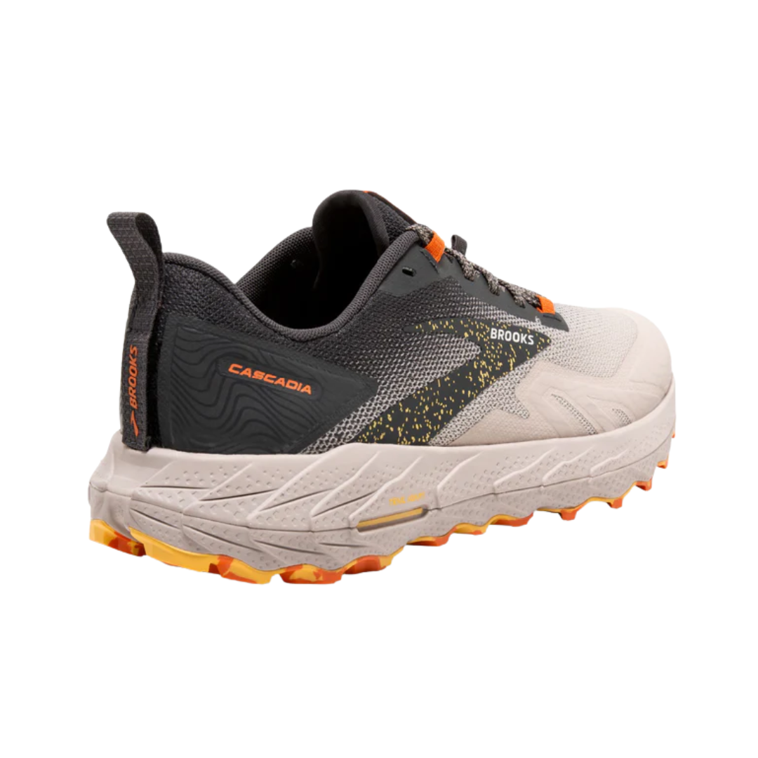 Angled heel view of the men’s Brooks Cascadia 17 trail running shoe in Chateau Grey/Forged Iron, featuring adaptive cushioning, protective trail-ready construction, and grippy TrailTack outsole for stability on rugged terrain; supportive design ideal for hikers and runners.