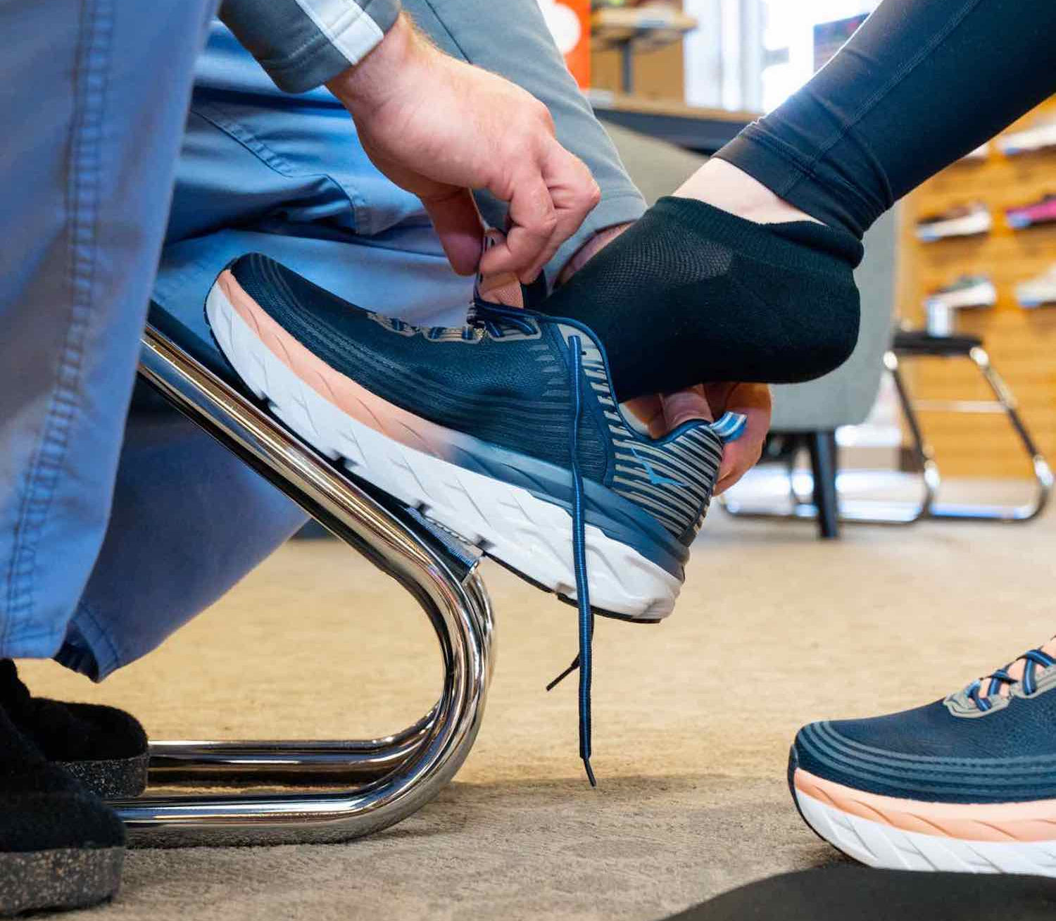 Fit My Feet employee fitting shoes and insoles for customer