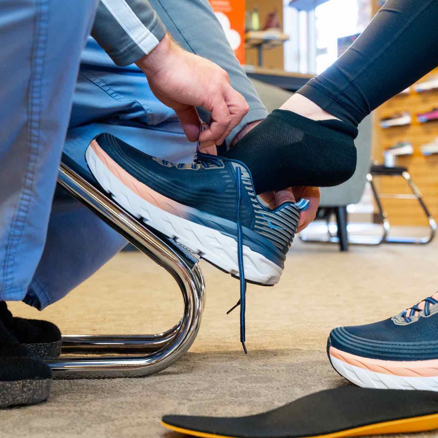 Fit My Feet employee fitting shoes and insoles for customer