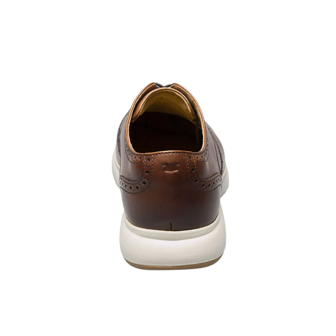 Back view of Men’s Dash Wing Tip in Cognac – showing a gently tapered heel with smooth leather construction, rear seam detailing, and a structured collar for a refined and secure fit.