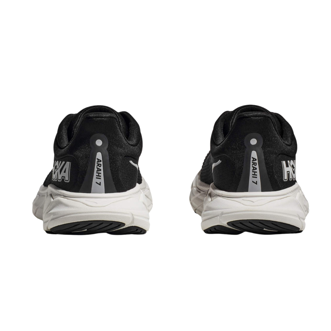 Back view of Women’s Arahi 7 running shoe in black and white – featuring molded heel counter for rearfoot stability, pull tab for easy on and off, and subtle branding details.