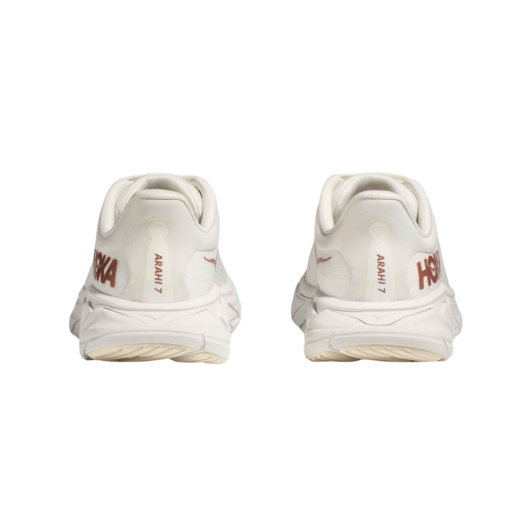 Back view of Women’s Arahi 7 running shoe in blanc de blanc and rose gold – featuring molded heel counter for rearfoot stability, pull tab for easy on and off, and subtle branding details.