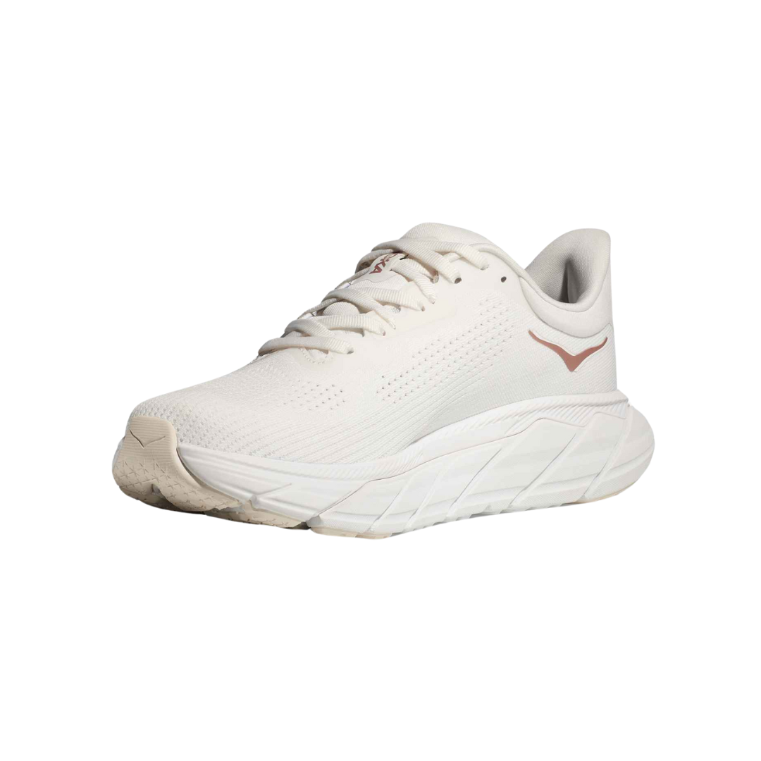 Angled view of Women’s Arahi 7 running shoe in blanc de blanc and rose gold – featuring breathable mesh panels for ventilation, supportive midsole with medial post for stability, and sleek silhouette optimized for running efficiency.