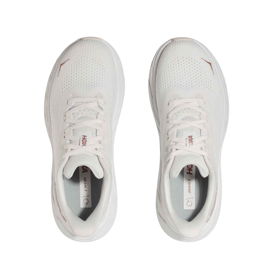Top view of Women’s Arahi 7 running shoe in blanc de blanc and rose gold – featuring padded tongue and collar for comfort, moisture-wicking lining to keep feet dry, and secure lace-up closure for locked-in fit.