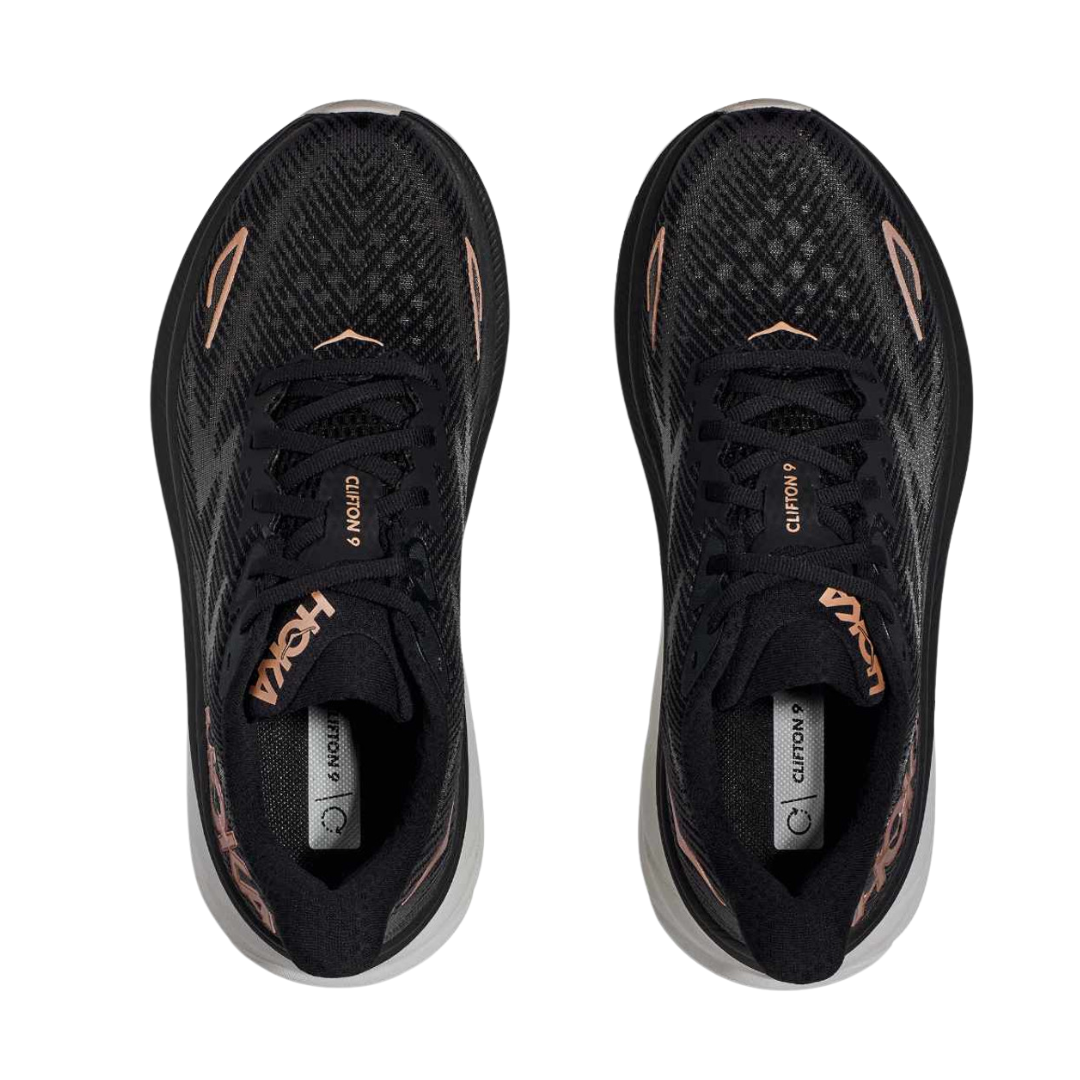 Top view of Women’s Clifton 9 running shoe in black and rose gold – featuring padded tongue and collar for comfort, moisture-wicking lining to keep feet dry, and traditional lace-up closure for secure fit.