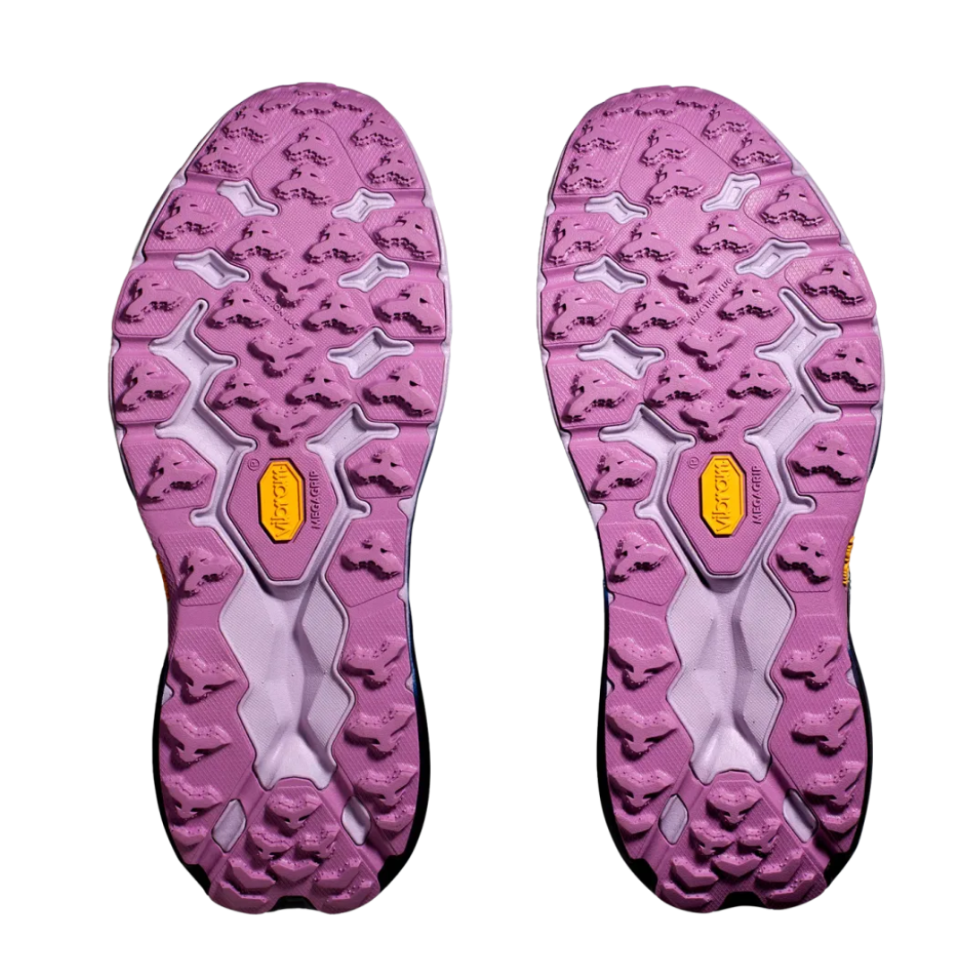 Bottom view of Women’s Speedgoat 5 trail running shoe in sunlit ocean and night sky – featuring a Vibram Megagrip outsole with aggressive multi-directional lugs for superior traction on varied terrain, flex grooves for natural foot movement, and slip-resistant tread to reduce fall risk.