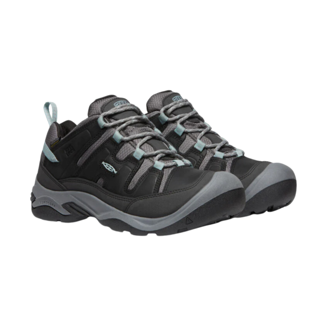 Side view of Women’s Circadia Low Waterproof hiking shoe in black and cloud blue – featuring a waterproof nubuck leather and mesh upper for weather protection, cushioned midsole with advanced shock absorption to reduce joint strain, and reinforced toe and heel overlays for durability.
