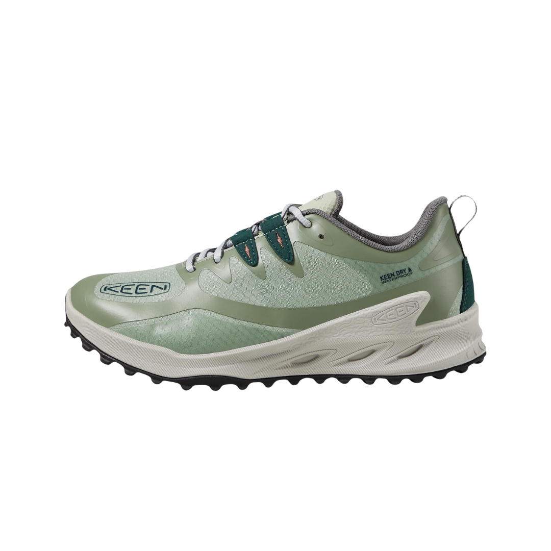 Side view of Keen Women's Zionic Waterproof Hiking Shoe in Desert Sage/Ember Glow – featuring a waterproof mesh and synthetic upper in sage green with ember orange accents, responsive midsole cushioning for all-day comfort, and a rugged outsole built for secure traction and stability on variable terrain.