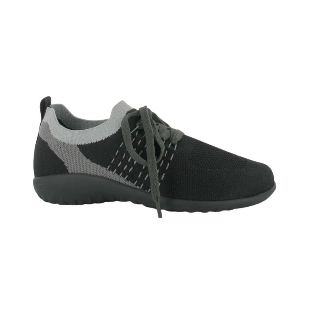 Side View of Women’s Naot Tama sandal in black and grey – featuring a soft leather and suede upper with an adjustable strap, a contoured cork and latex footbed, and a flexible low wedge sole for all-day comfort.