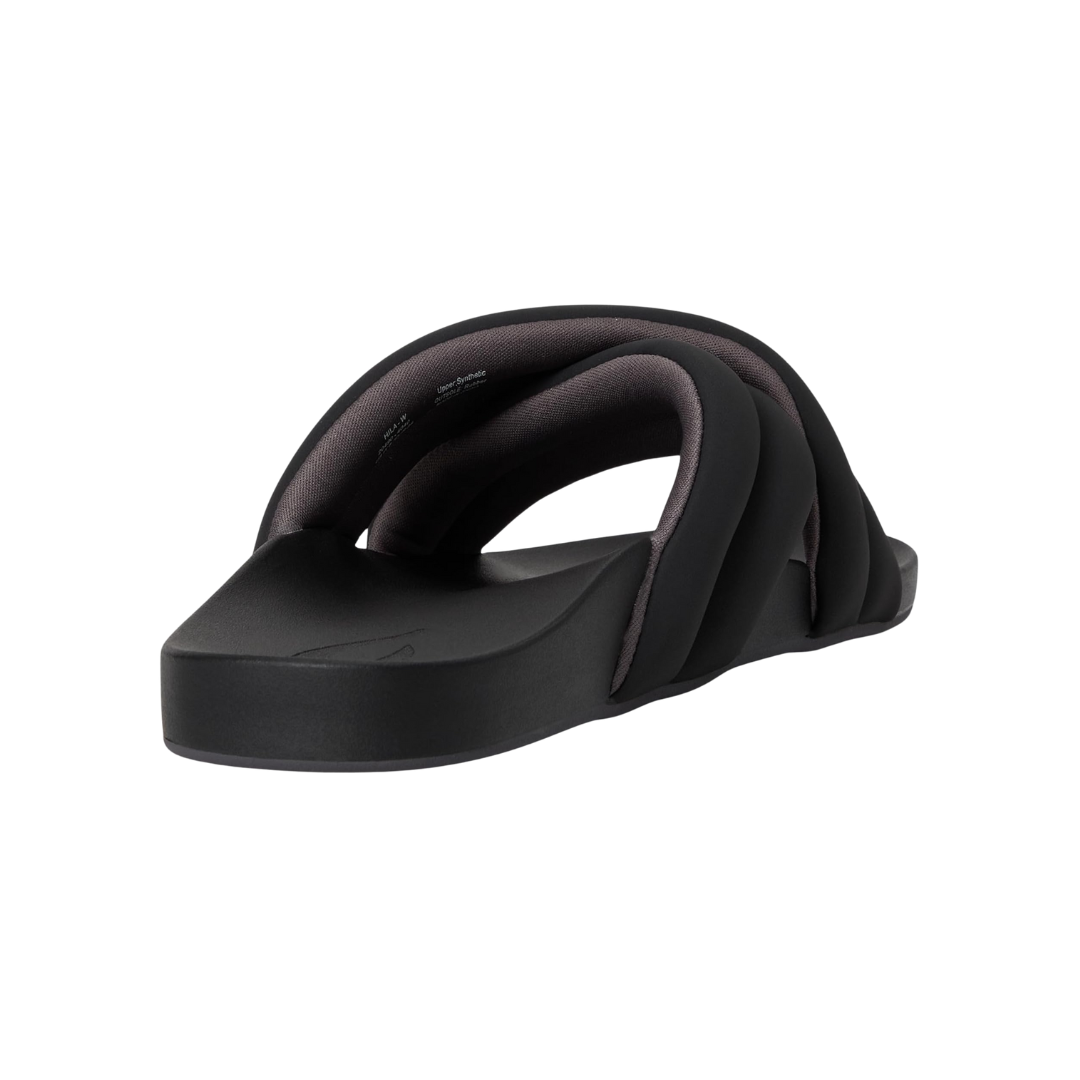 Angled view of Women’s Olukai Hila sandal in black – features include a water-friendly synthetic strap, plush cushioned footbed with arch support, slim and stylish profile, and a textured outsole for added stability.