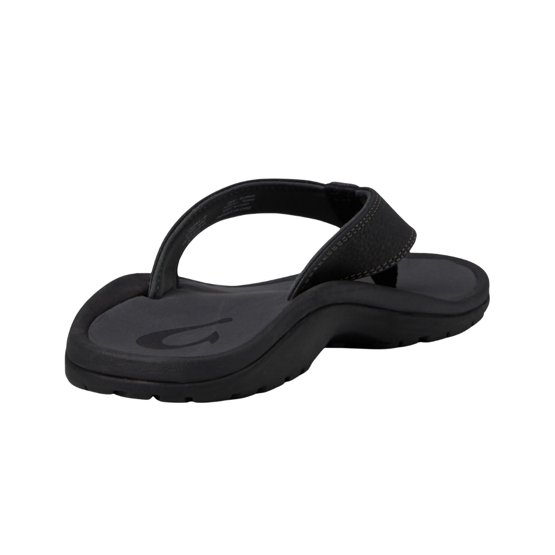 Angled view of Men’s Olukai Ohana sandal in Black/Dark Shadow – featuring a water-friendly synthetic upper, anatomical footbed with arch support, grippy outsole, and soft inner lining for comfort in and out of the water.