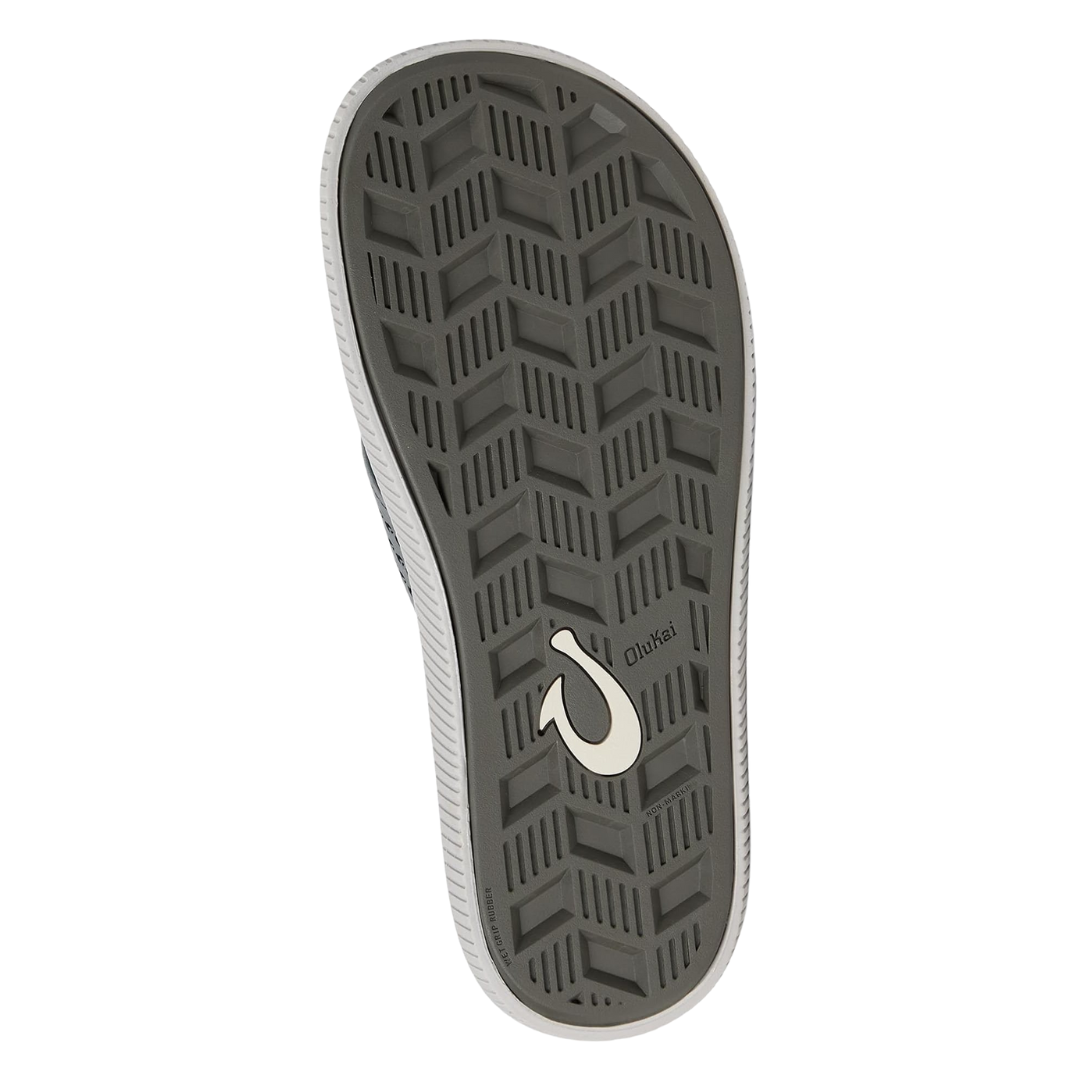 Bottom view of Men’s Olukai Ulele sandal in stone – features include a non-marking rubber outsole with razor siping for enhanced traction on wet surfaces, durable tread pattern, and water-friendly design.