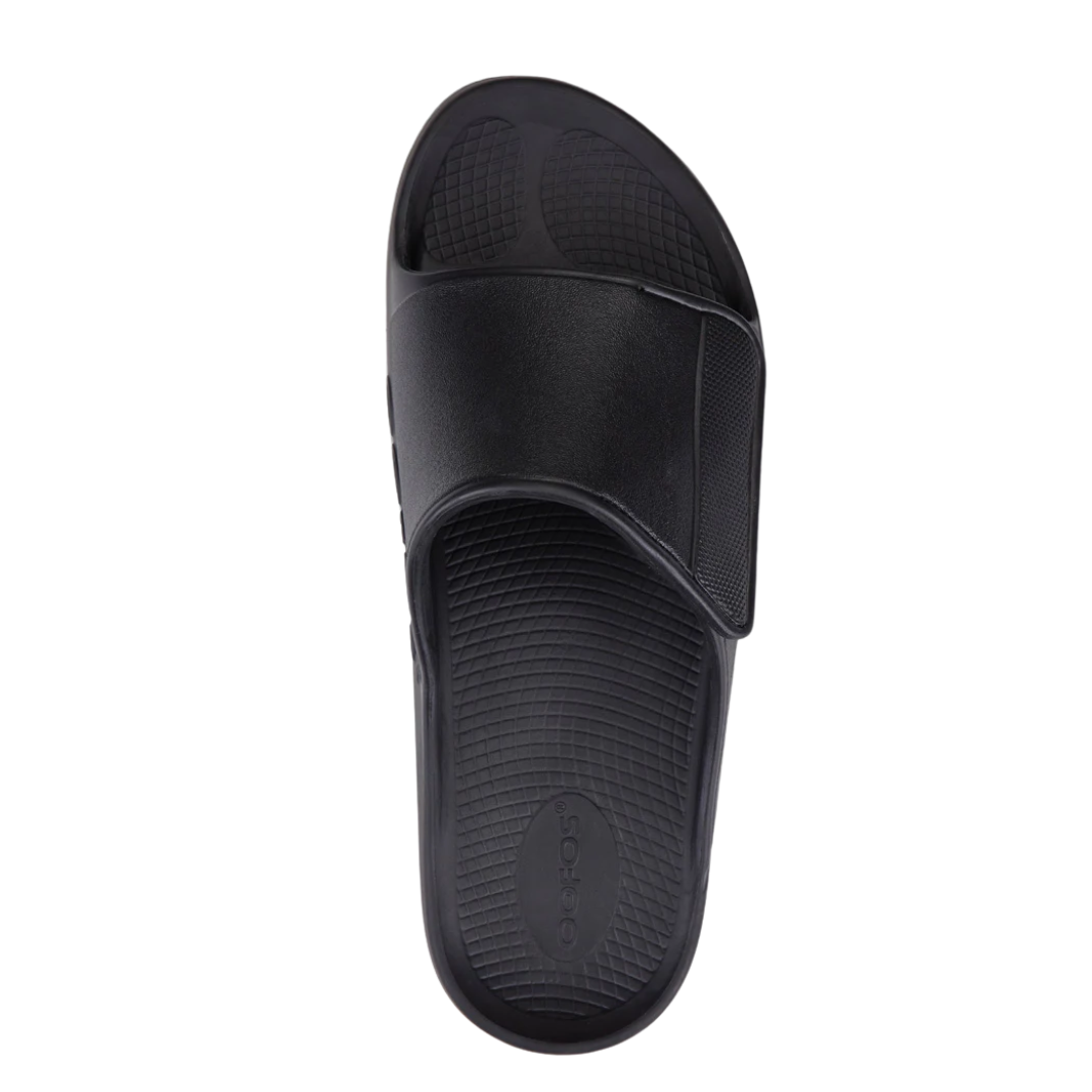 Top view of Men’s OOFOS Ooahh Sport Flex Sandal in matte black – featuring a matte-finish adjustable hook-and-loop strap, wide slide-in opening, contoured footbed with arch support, and smooth, seamless construction for enhanced comfort.