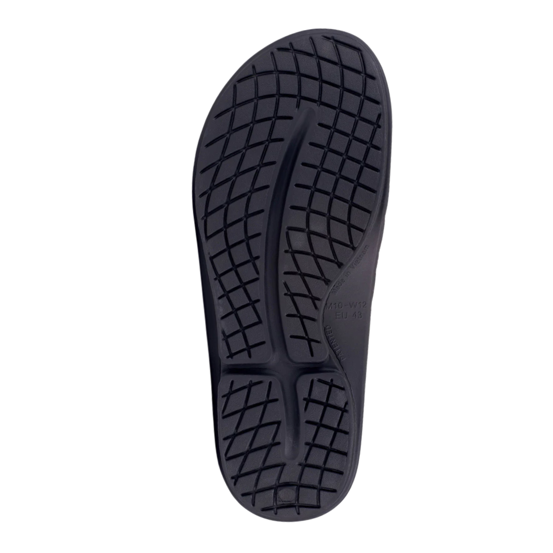 Bottom view of OOFOS Ooahh Sport Flex Sandal in matte black – featuring a slip-resistant OOfoam™ outsole with textured tread, flexible cushioning for natural motion, and a durable recovery-optimized design.