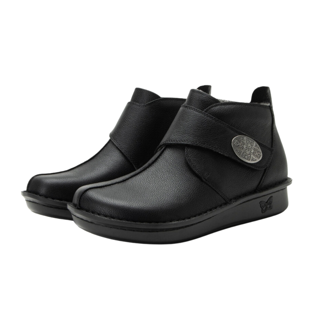 Side View of Women’s Alegria Caiti boot in upgrade black – featuring a cushioned cork and memory foam footbed, side zipper with adjustable buckle strap, and slip-resistant outsole for versatile wear.