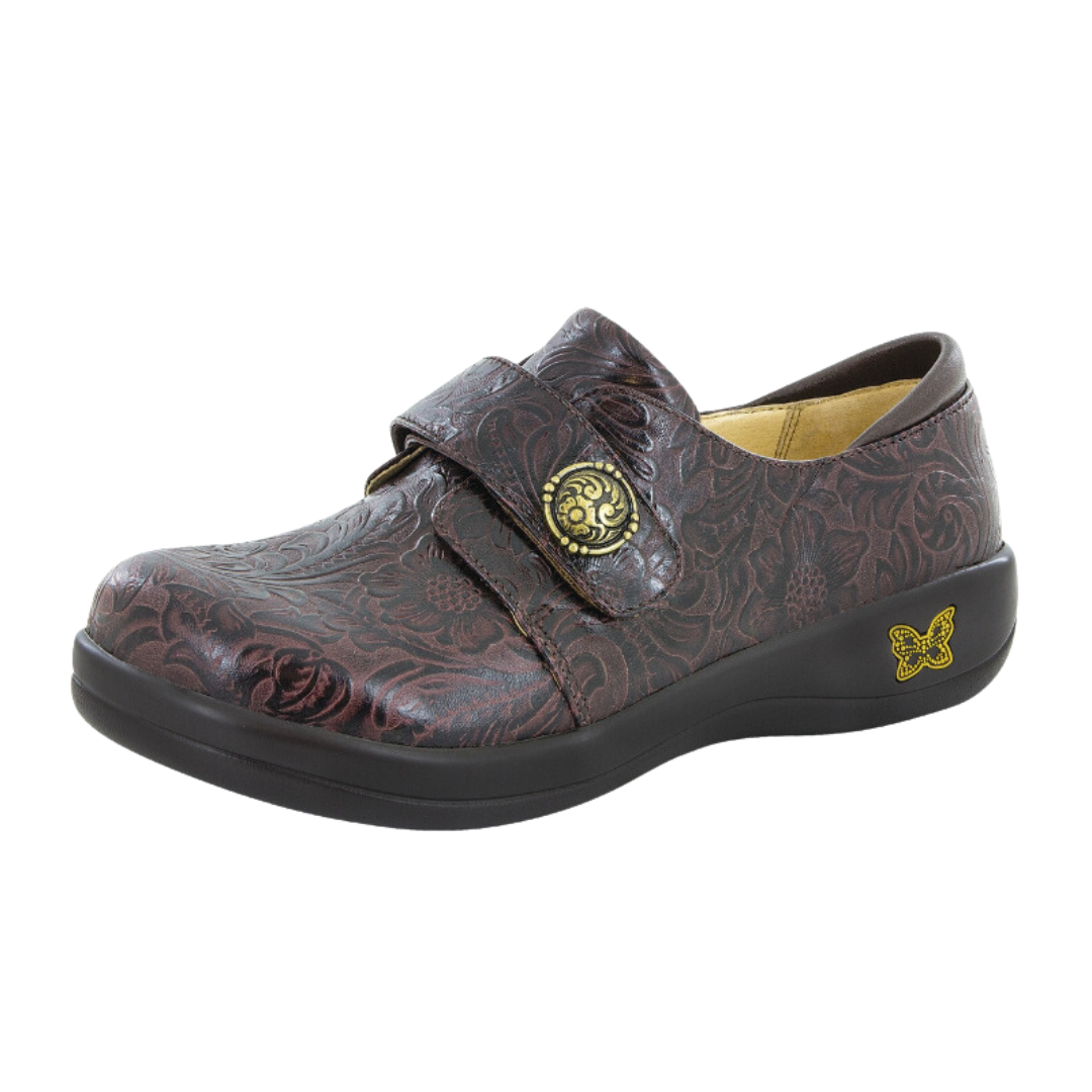 Side View of Women’s Alegria Joleen shoe in molasses tooled brown – featuring a cushioned removable footbed, adjustable hook-and-loop strap, and slip-resistant outsole for secure wear.