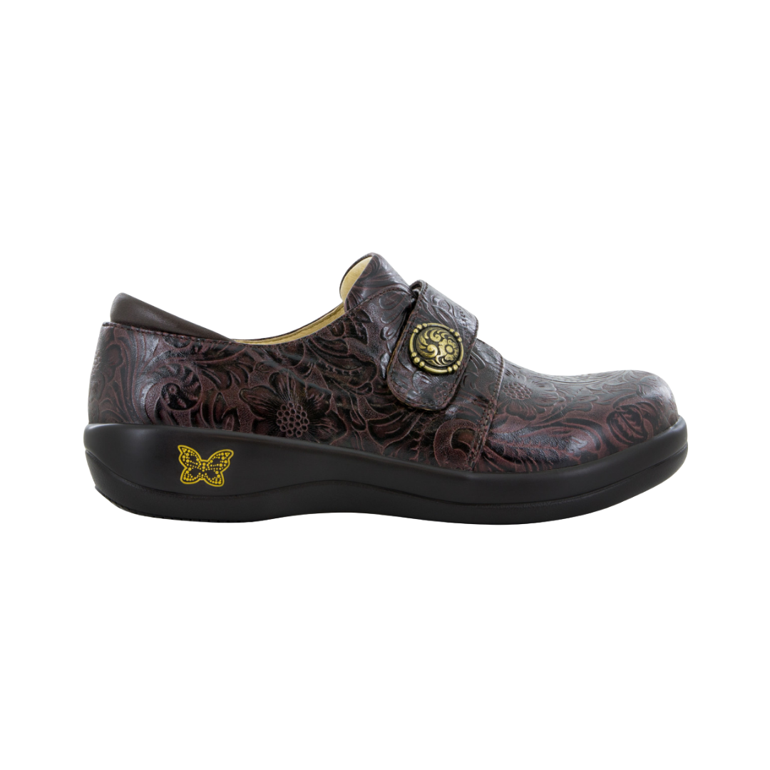Side View of Women’s Alegria Joleen shoe in molasses tooled brown – featuring a cushioned removable footbed, adjustable hook-and-loop strap, and slip-resistant outsole for lasting comfort.